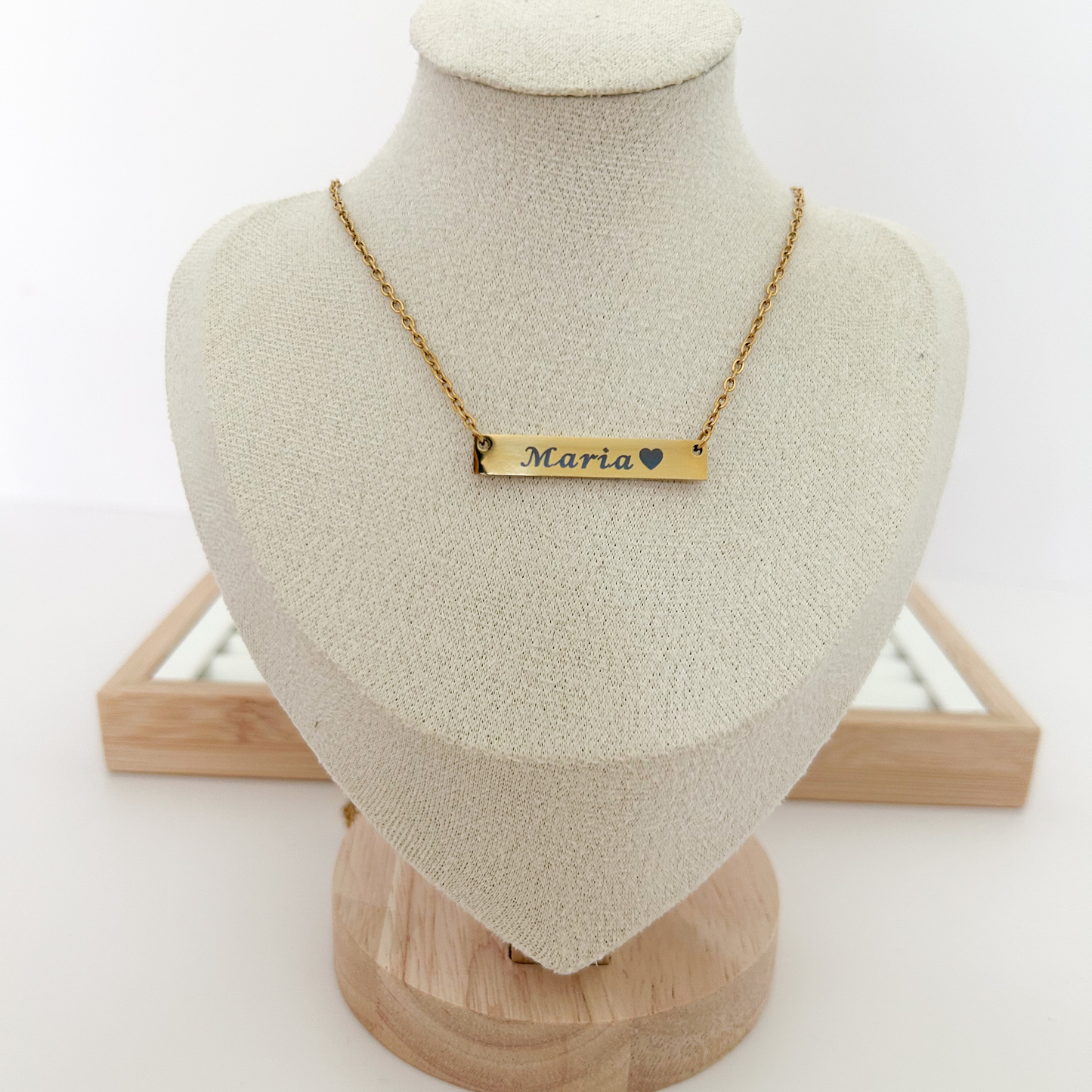 Gold necklace with 'Maria' engraving on a mannequin bust against a white background