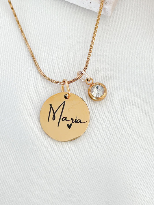 Gold necklace with a round pendant engraved with 'Maria' on a white background