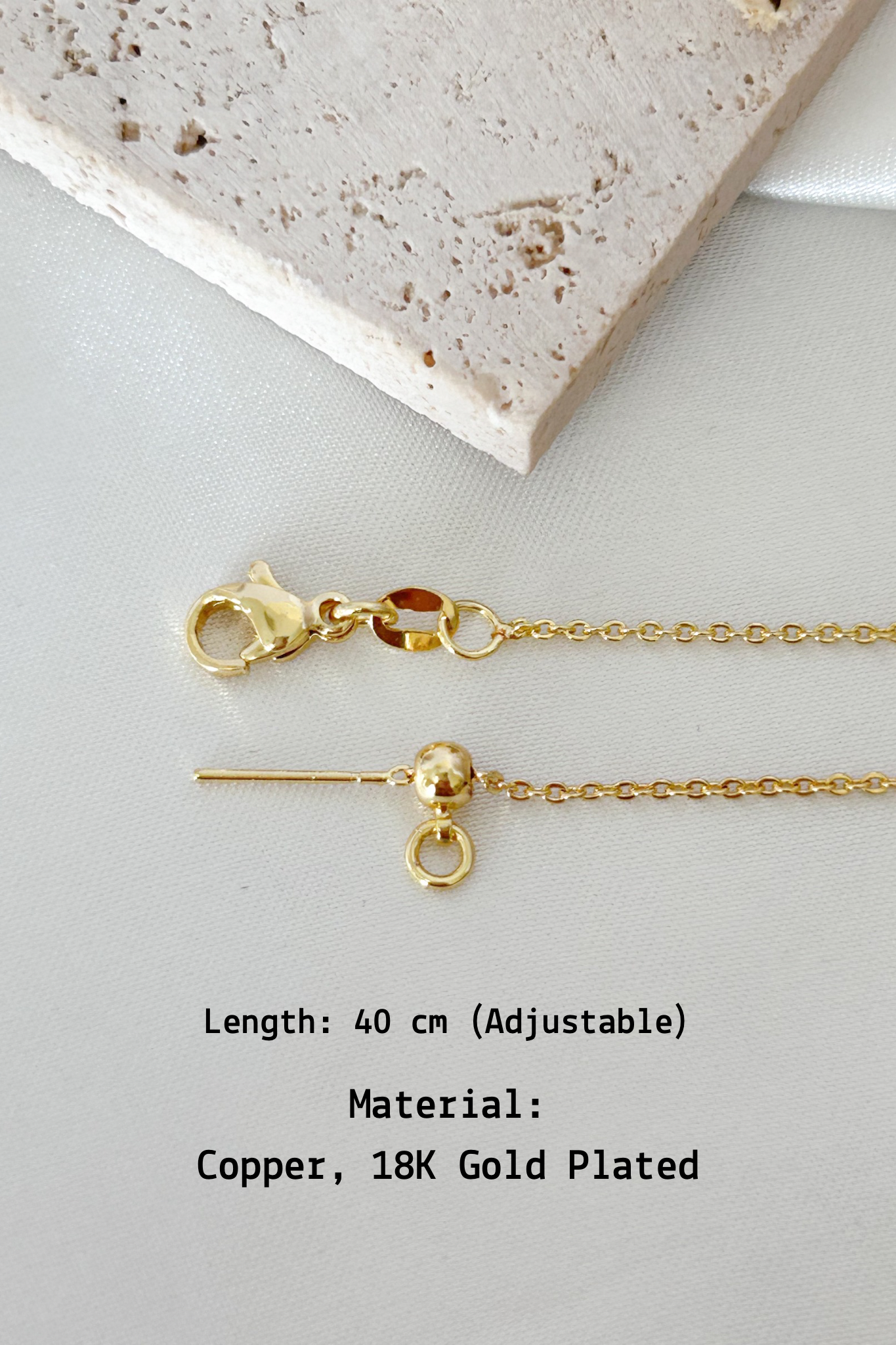 Gold necklace with clasp on a light gray surface