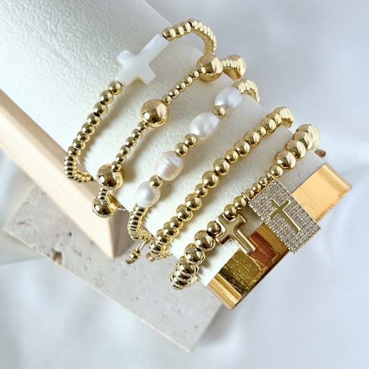 Gold and pearl beaded bracelet with a gold padlock charm on a white surface