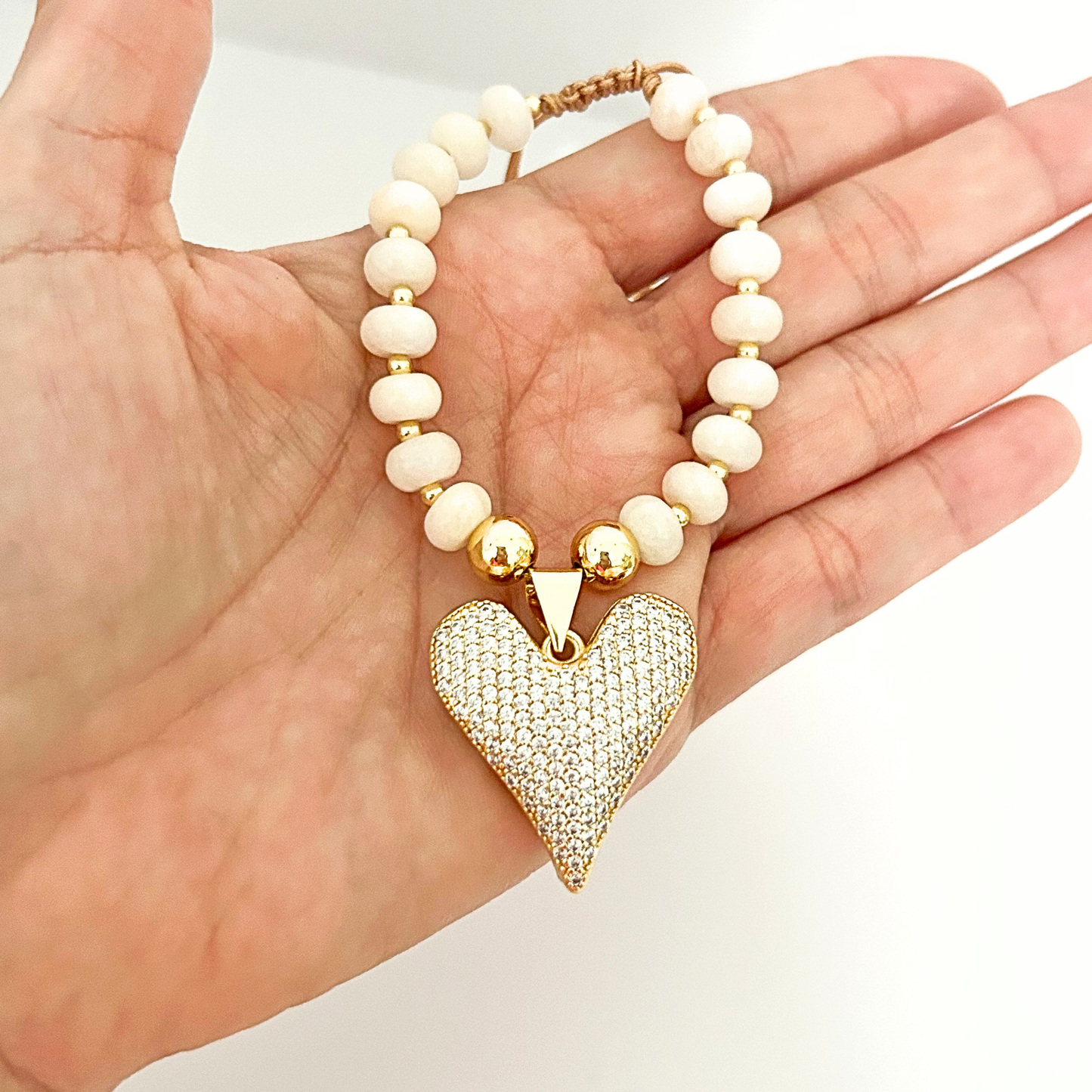 Chic ivory beaded bracelet featuring a crystal heart pendant and gold-tone accents, ideal for gifting or daily styling.