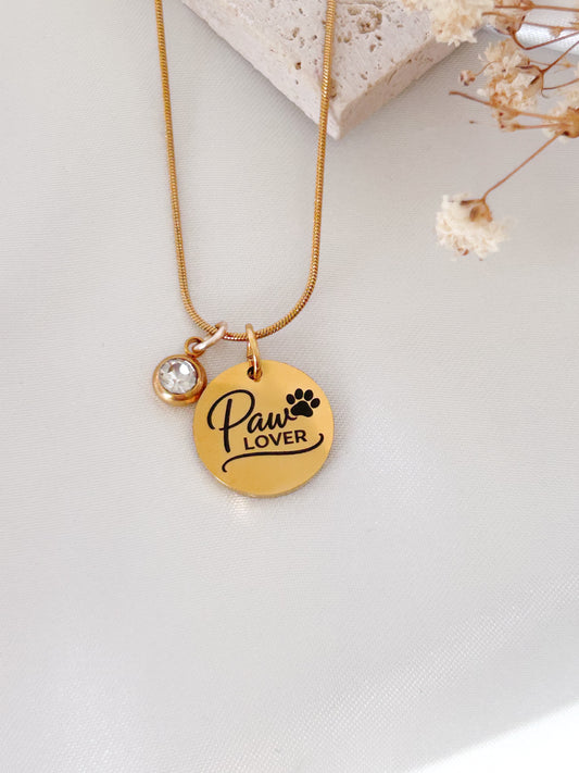 Gold necklace with 'Paw Lover' pendant on a light background