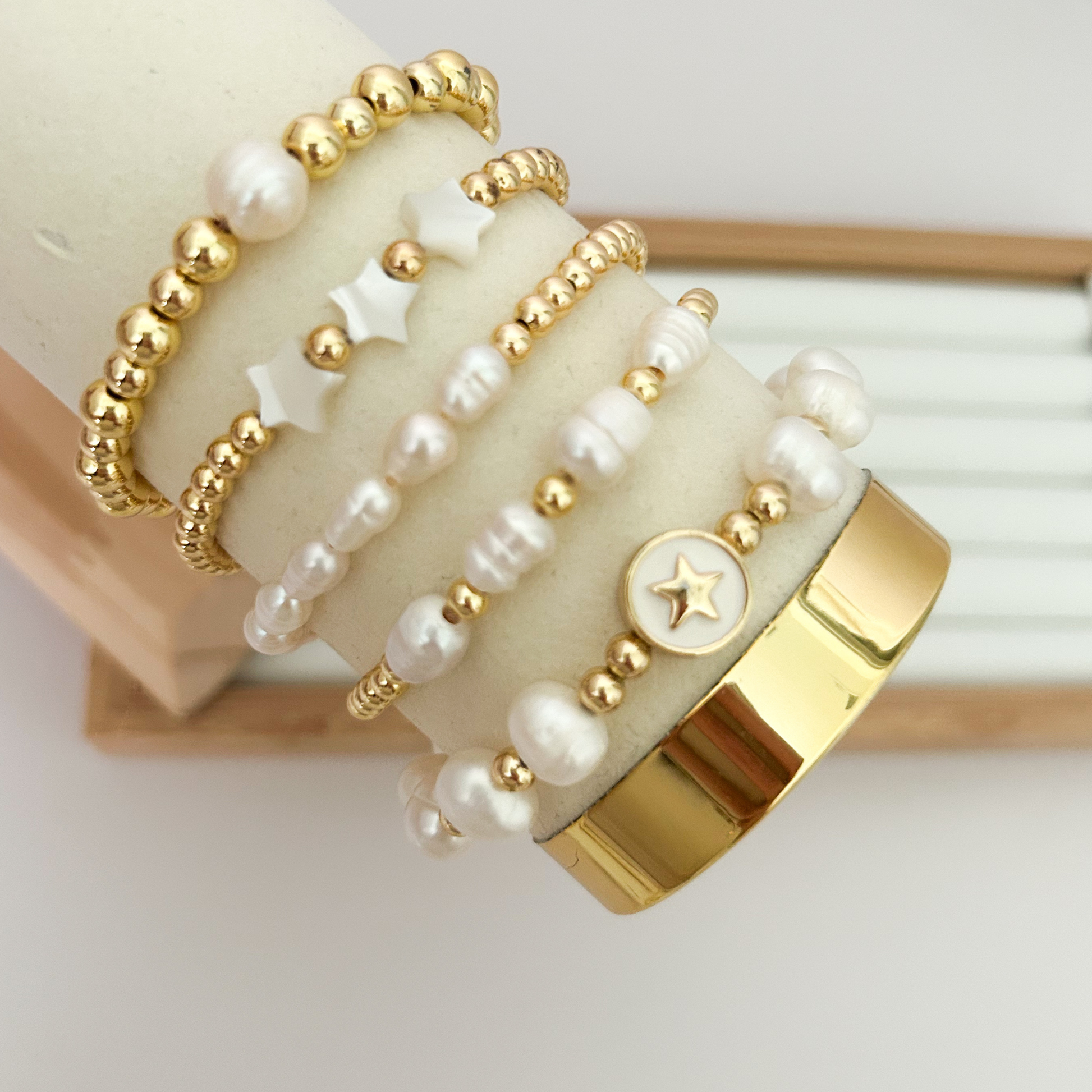 White star pearl gold bracelet set displayed on jewelry stand