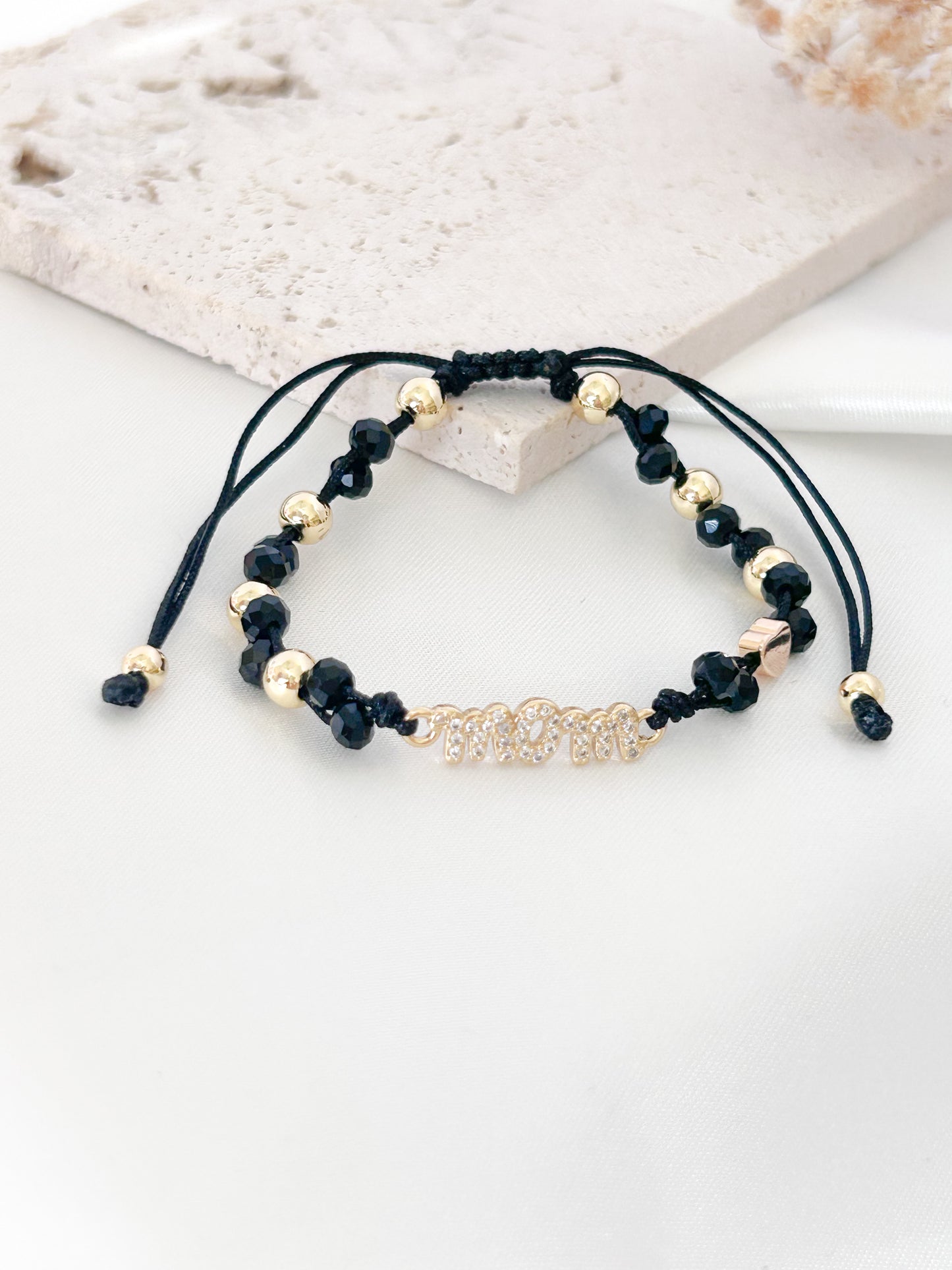 Black and gold beaded bracelet on a white surface
