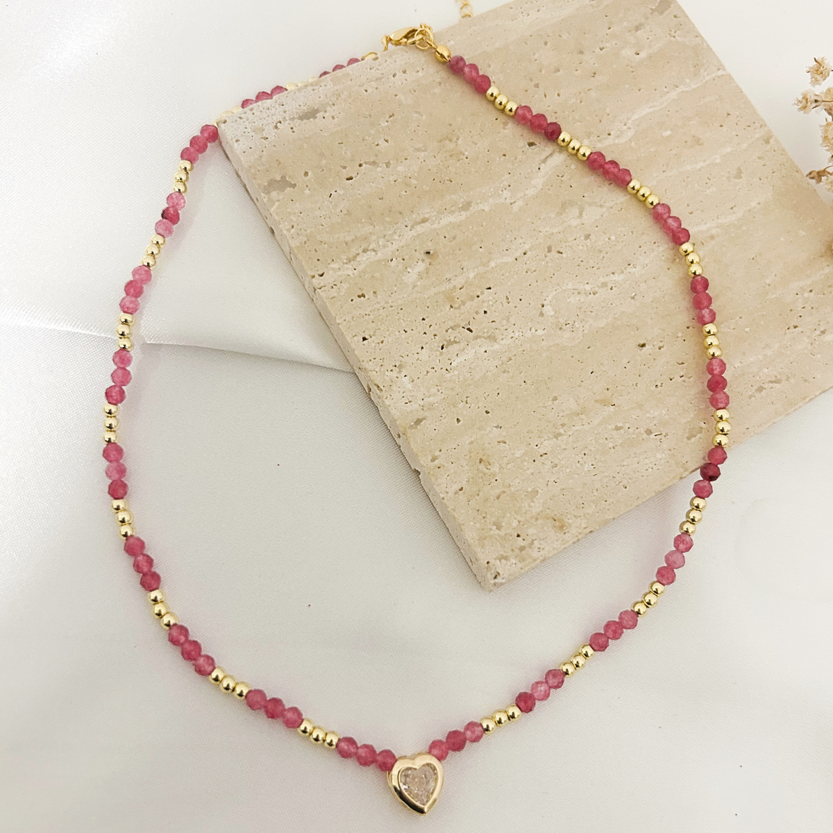 Pink tourmaline choker coiled on a stone tray, showing full length and clasp