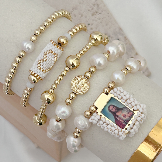 Gold and pearl bracelet with a small framed picture on a beige surface
