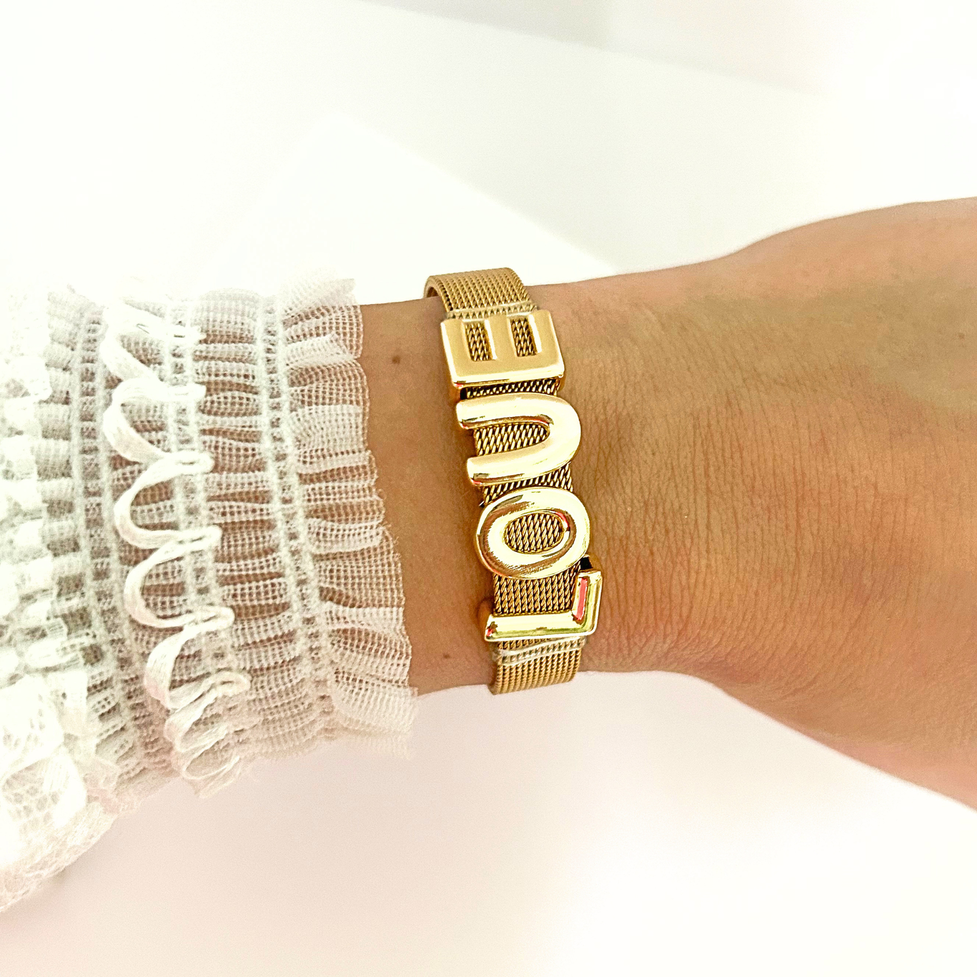 Adjustable gold LOVE bracelet worn on the wrist, showcasing a sleek and contemporary style.