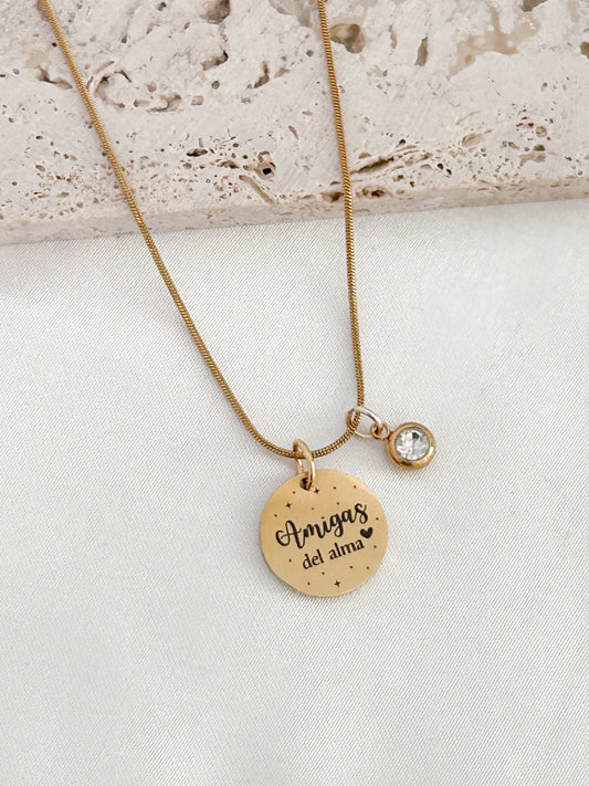 Gold necklace with a round pendant on a light background