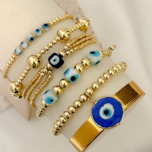 Gold beaded bracelet set with blue evil eye charms, minimalist handmade stack jewelry for everyday protection and style