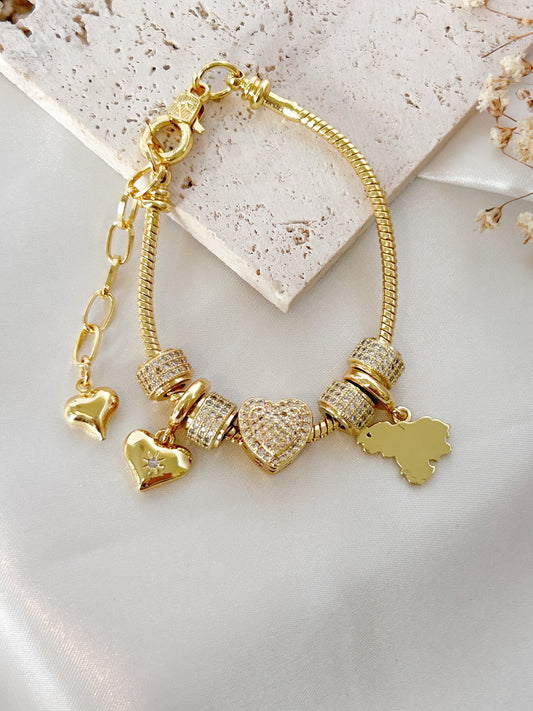 Gold bracelet with heart-shaped charms on a light background