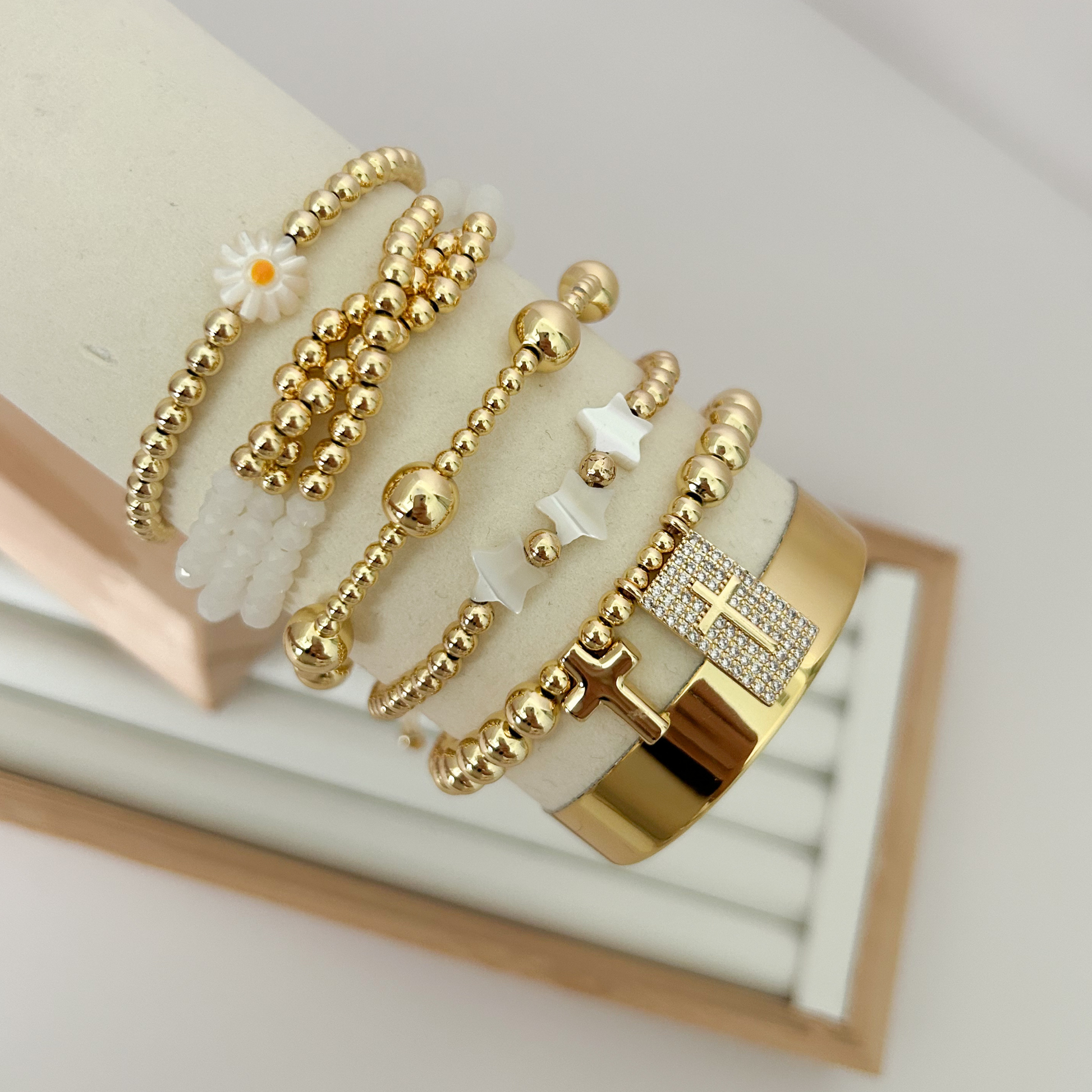 Daisy cross white gold bracelet set displayed on jewelry stand