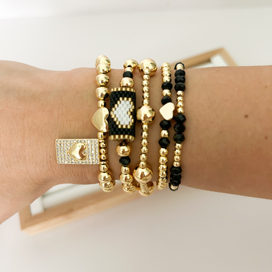 Black crystal and gold bracelet stack with pavé rectangular charm styled on wrist