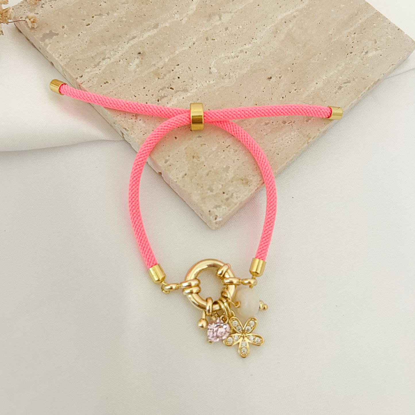Neon pink cord bracelet with flower and stone charms