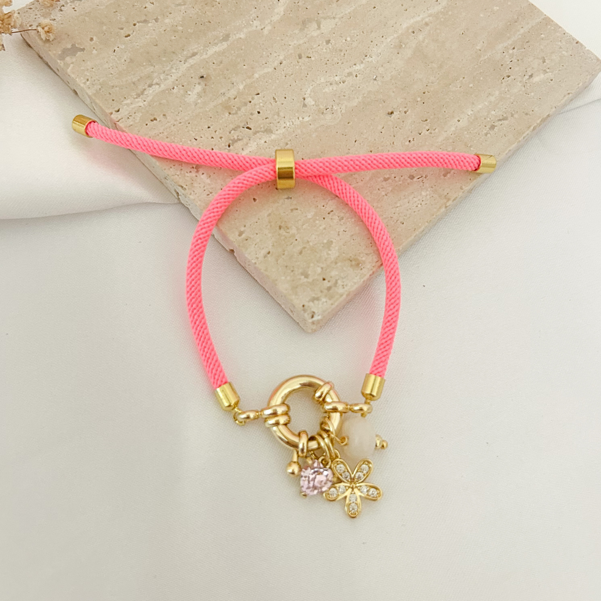 Neon pink cord bracelet with flower and stone charms