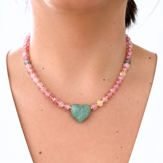 Model wearing a gemstone necklace with soft pink faceted beads, gold accents, and a polished green heart pendant. A feminine and eye-catching piece perfect for everyday wear or special occasions.