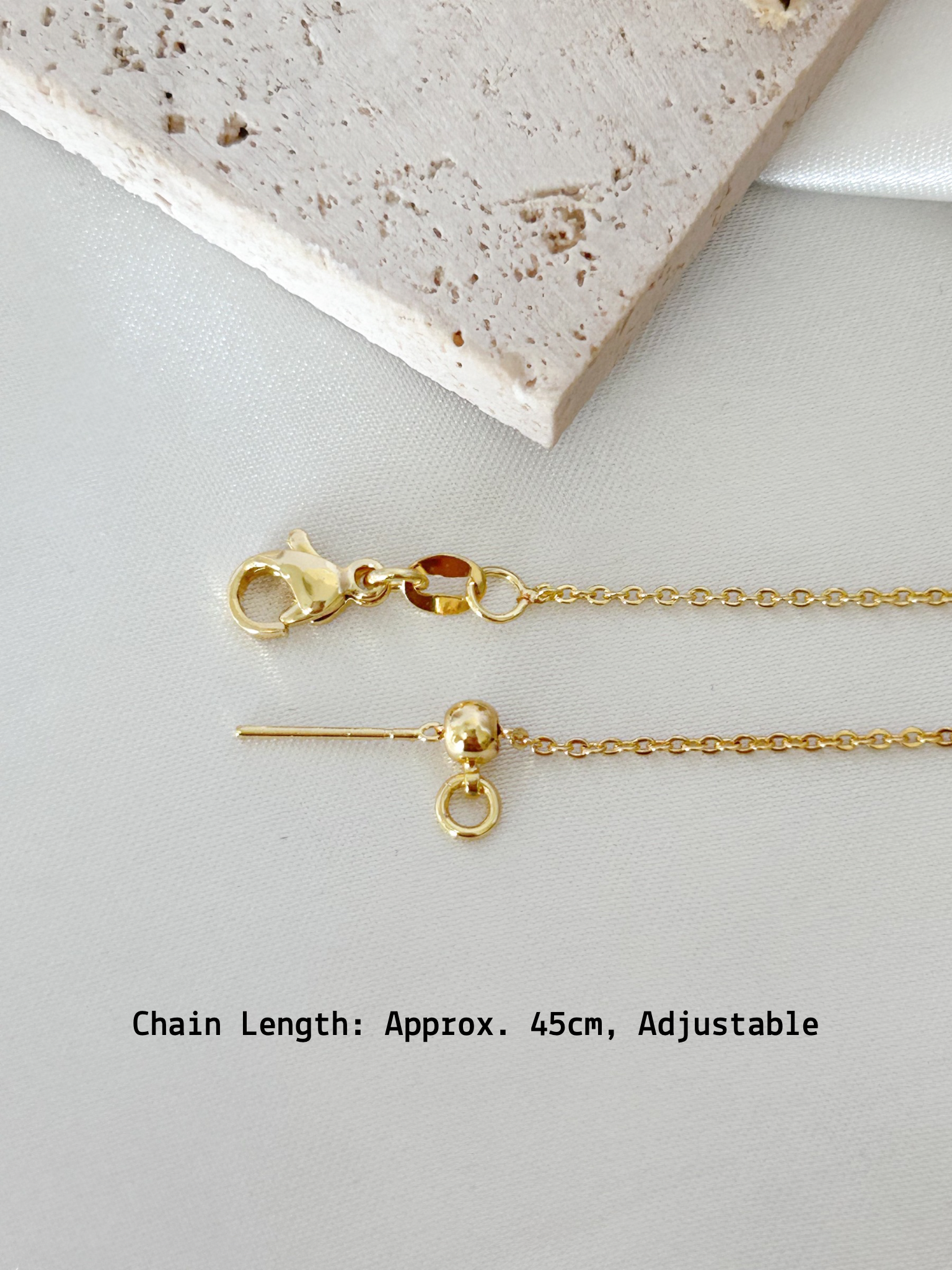 Gold necklace with clasp on a light gray surface