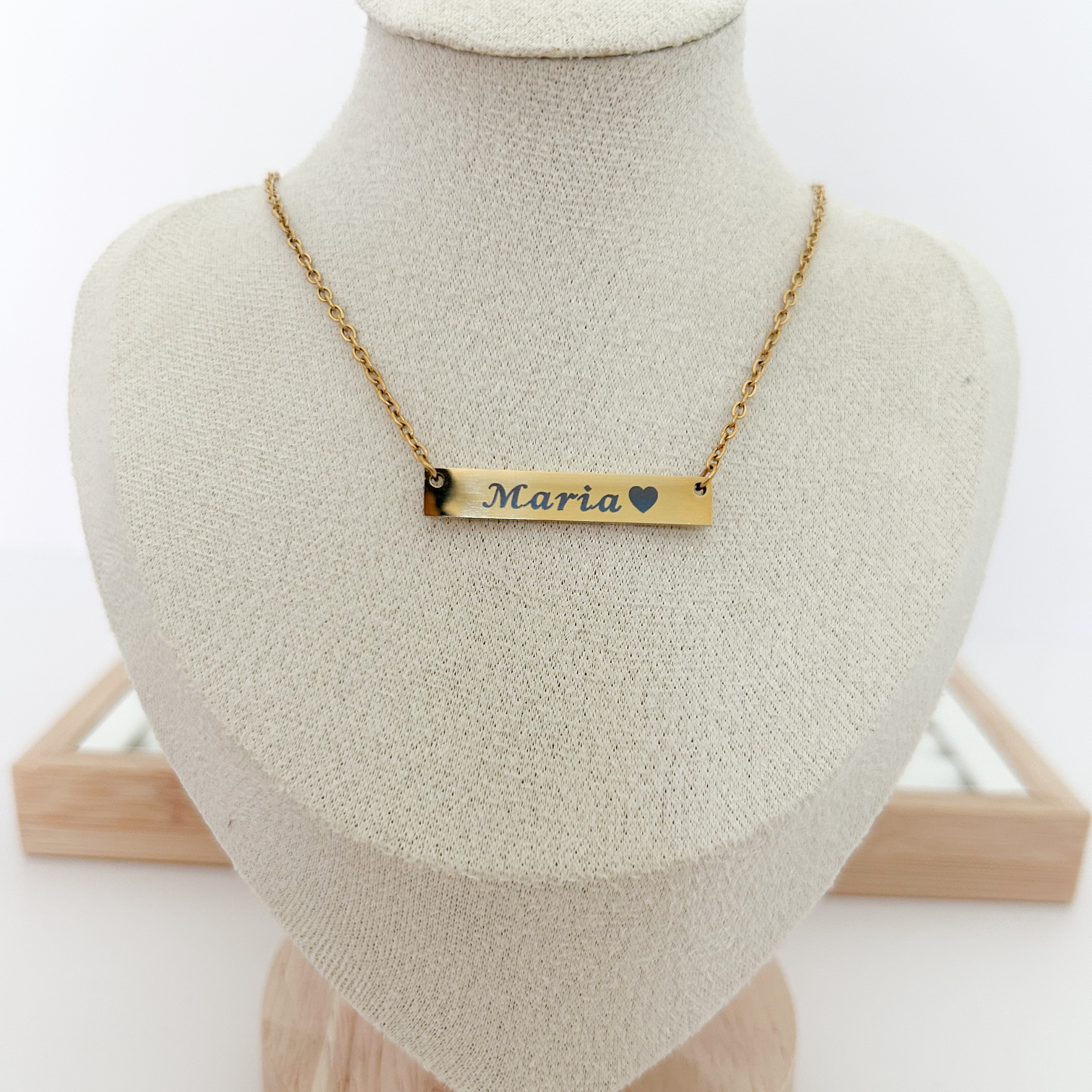 Gold necklace with a nameplate on a mannequin bust