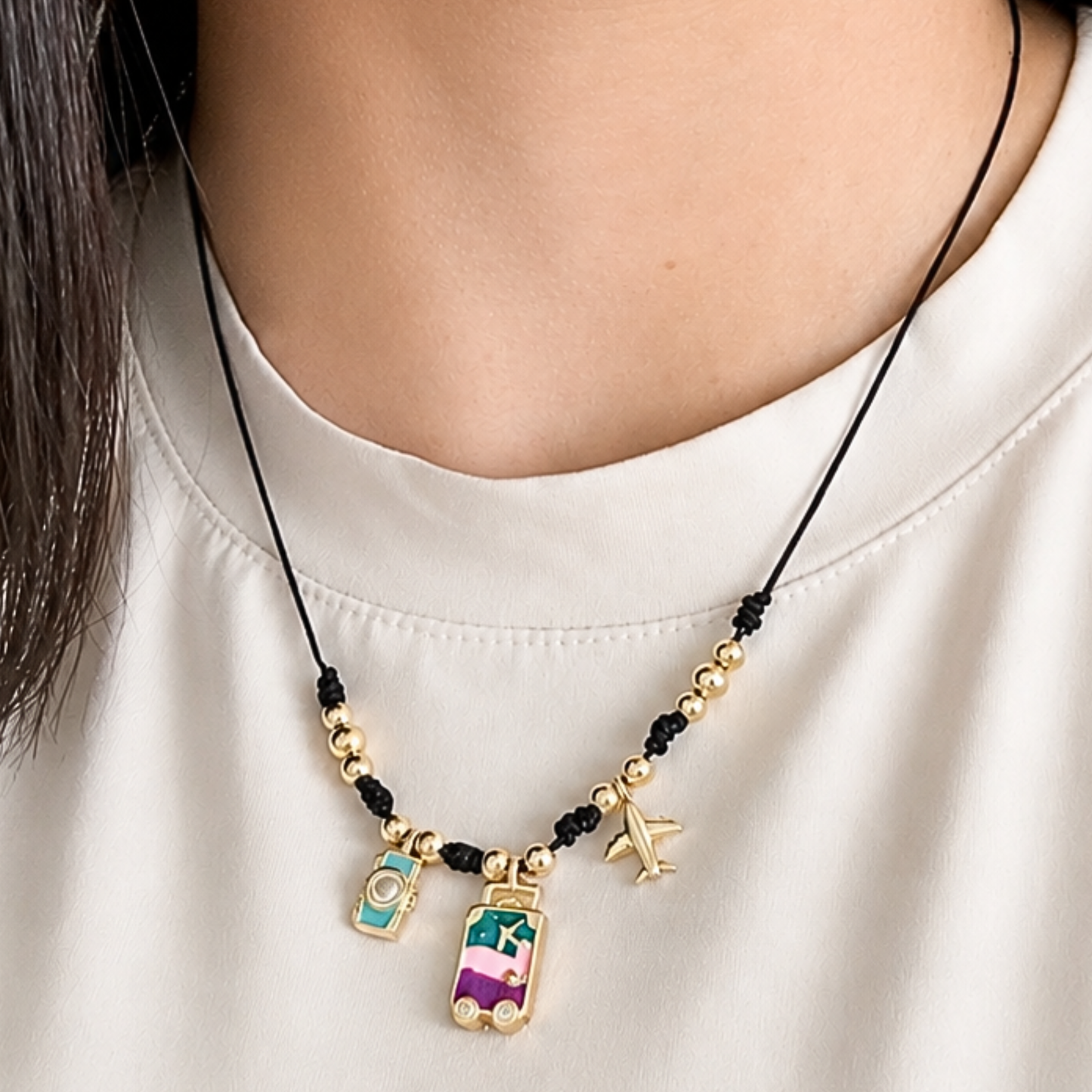 Necklace with travel-themed charms on a white shirt